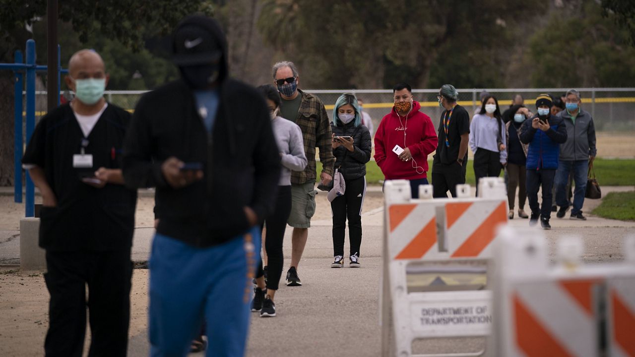 People wait in line to get their COVID-19 vaccine at a vaccination site set up in a park in the Lincoln Heights neighborhood of Los Angeles, Tuesday, Feb. 9, 2021. (AP Photo/Jae C. Hong)
