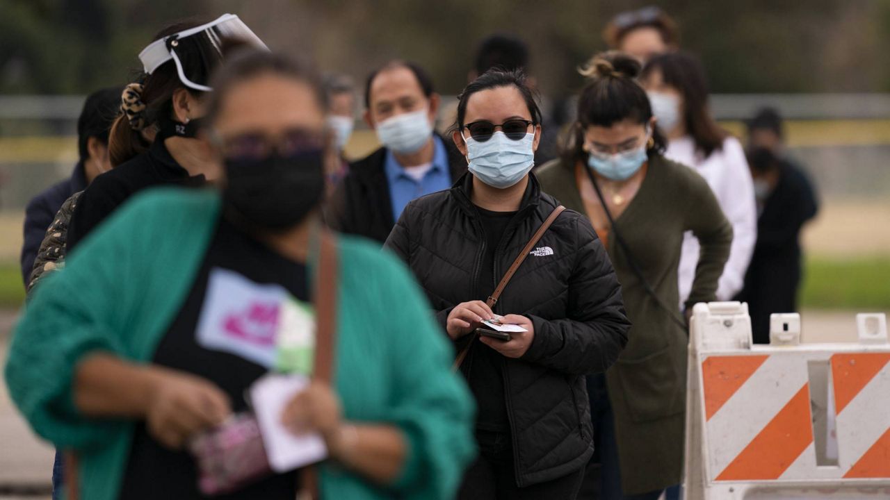 People wait in line to get their COVID-19 vaccine at a vaccination site set up in a park in the Lincoln Heights neighborhood of L.A., Feb. 9, 2021. (AP Photo/Jae C. Hong)