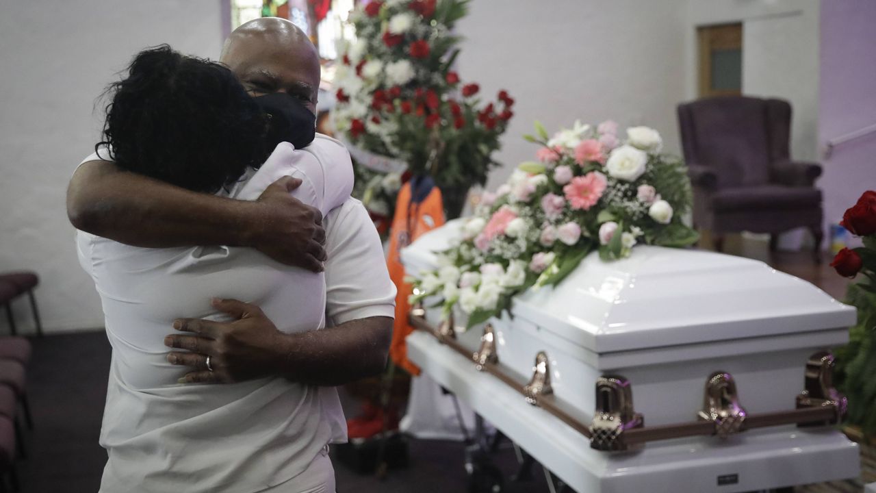In this July 21, 2020, file photo, Darryl Hutchinson, facing camera, is hugged by a relative during a funeral service in Los Angeles for Lydia Nunez, his cousin who died of COVID-19. (AP Photo/Marcio Jose Sanchez, File)