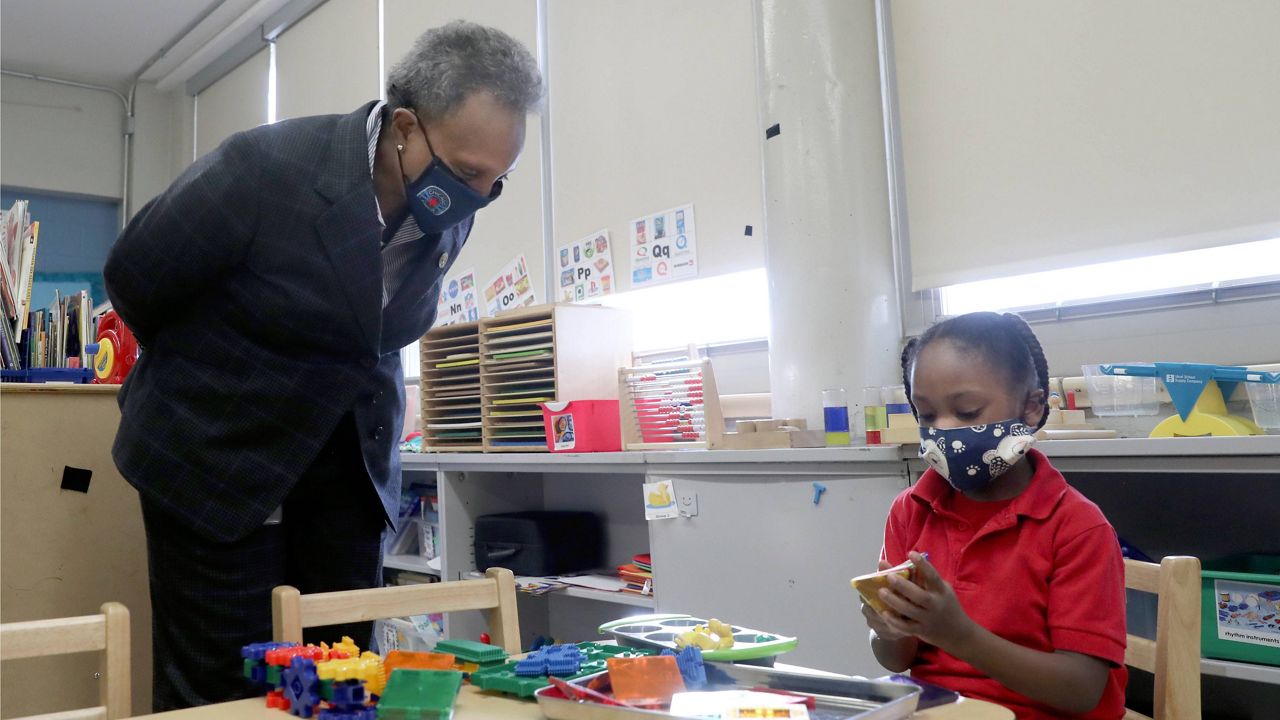 Chicago Mayor Lori Lightfoot talks with a student at William H. Brown Elementary School on Feb. 11, 2021. (AP Photo/Shafkat Anowar, Pool, File)