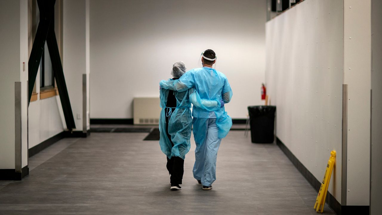 Registered traveling nurses Subrina Geer, left, and husband, Edward Rojas, of New York City, walk the hallways during their shift a field hospital set up to handle a surge of COVID-19 patients, Wednesday, Feb. 10, 2021, in Cranston, R.I. The couple saw the disease ravage New York City hospitals last year. This is different: "It was a breath of fresh air to see how many patients we could discharge," Geer said. "It's a thrill in a way compared to what I saw in New York." 