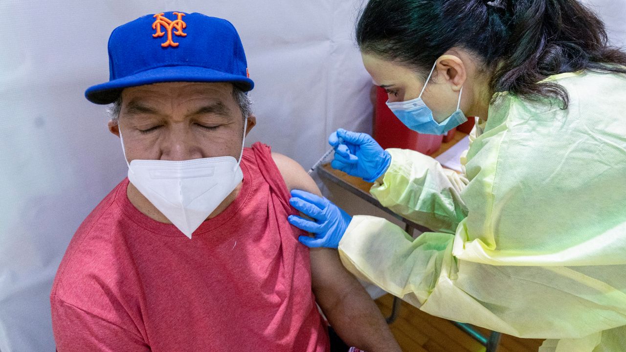 A nurse gives a man a COVID-19 vaccine at the Bronx River Addiction NYCHA complex, on January 31, 2021. (AP Photo/Mary Altaffer)