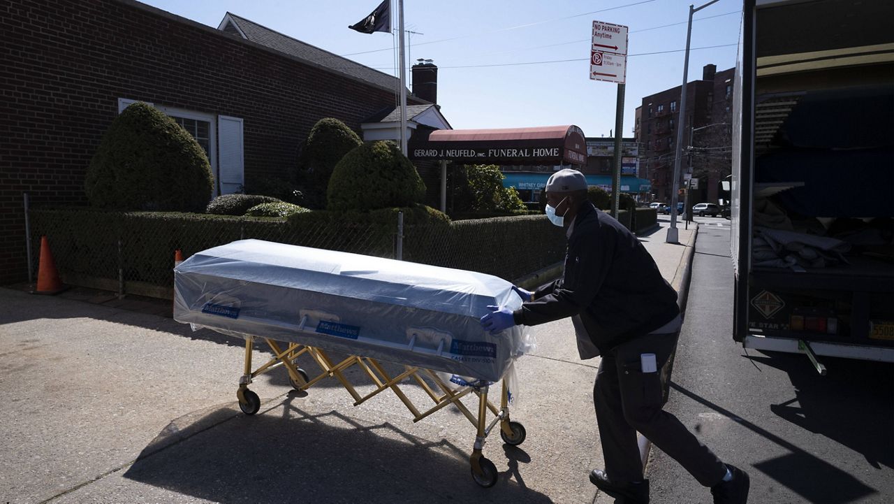 In this March 27, 2020, file photo, William Samuels delivers caskets to the Gerard Neufeld Funeral Home in the Queens borough of New York. (AP Photo/Mark Lennihan)