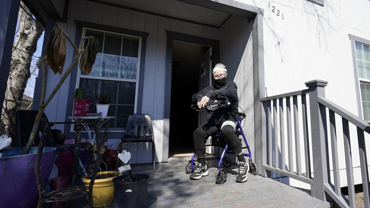 Nancy Wilson sits on her porch after returning from a water distribution site Friday, Feb. 19, 2021, in Houston. Wilson does not have full running water. (AP Photo/David J. Phillip)