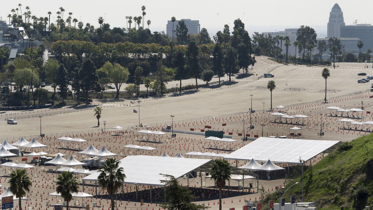 Traffic cones line around the empty tents at the parking lot of Dodger Stadium, a mass COVID-19 vaccination in Los Angeles, Friday, Feb. 19, 2021. California has closed some vaccination centers and delayed appointments following winter storms elsewhere in the country that hampered the shipment of doses. (AP Photo/Damian Dovarganes)