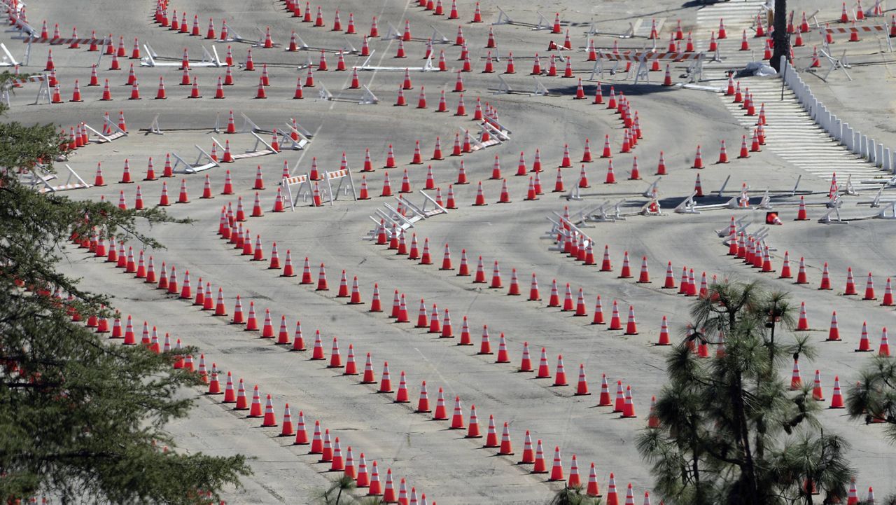 Traffic cones line around the empty parking lot of Dodger Stadium, a mass COVID-19 vaccination in Los Angeles, Friday, Feb. 19, 2021. (AP Photo/Damian Dovarganes)