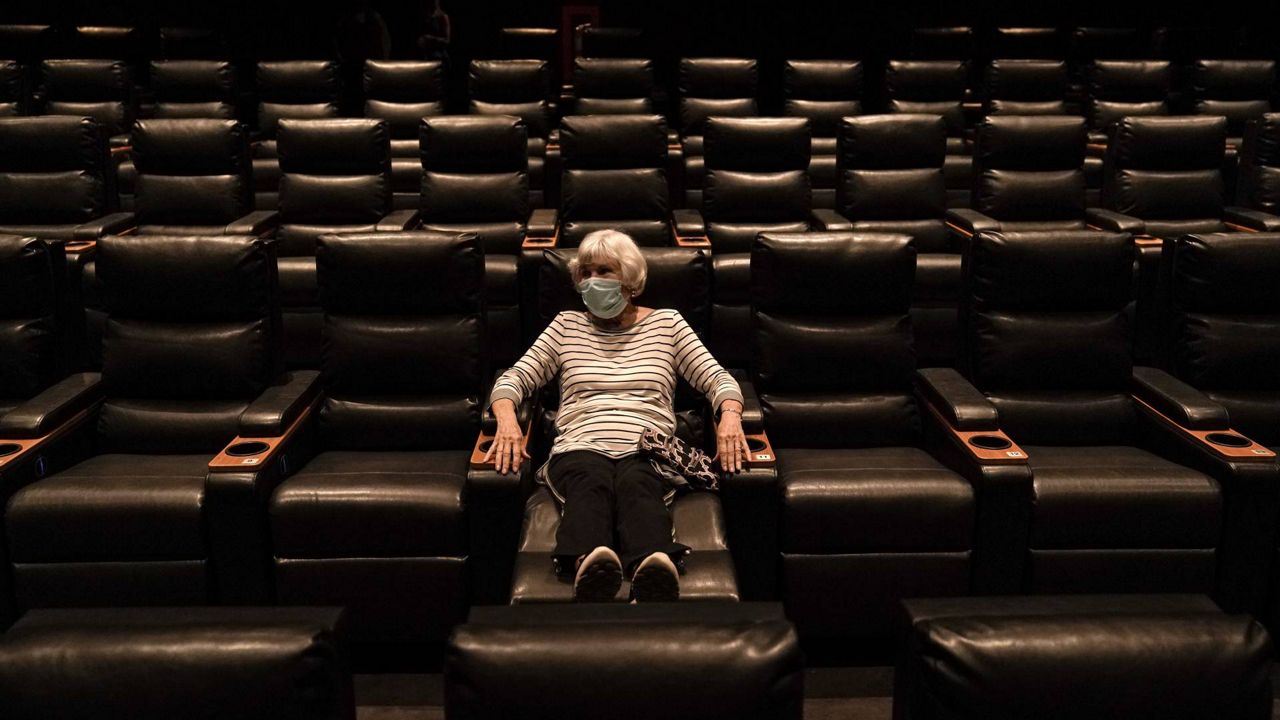 Karen Speros, 82, waits for a movie to start at a Regal movie theater in Irvine, Calif., Sept. 8, 2020. (AP Photo/Jae C. Hong)