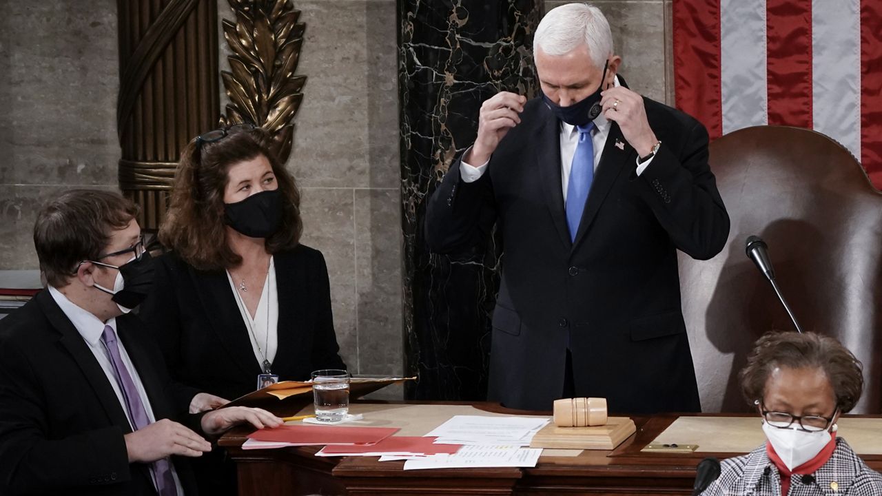 In this Jan. 6, 2021, photo, Senate Parliamentarian Elizabeth MacDonough, left, works beside then-Vice President Mike Pence during the certification of Electoral College ballots in the presidential election, in the House chamber at the Capitol in Washington. (AP Photo/J. Scott Applewhite)