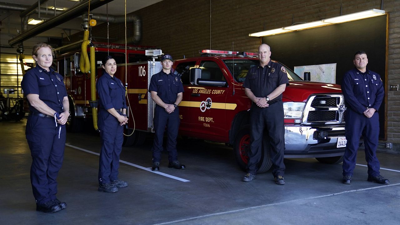 From left, fire Truck Captain Jeane Barrett, firefighter paramedic Sally Ortega, engine probationary firefighter Cole Gomoll, Battalion Chief Dean Douty, and Engine Captain Joe Peña, all first responders from Los Angeles County Fire Department - Station 106, pose for a photo at their station Friday, Feb. 26, 2021, in Rancho Palos Verdes, Calif, a suburb of Los Angeles. The crew responded to the scene of a vehicle crash involving golfer Tiger Woods on Tuesday. (AP Photo/Ashley Landis)