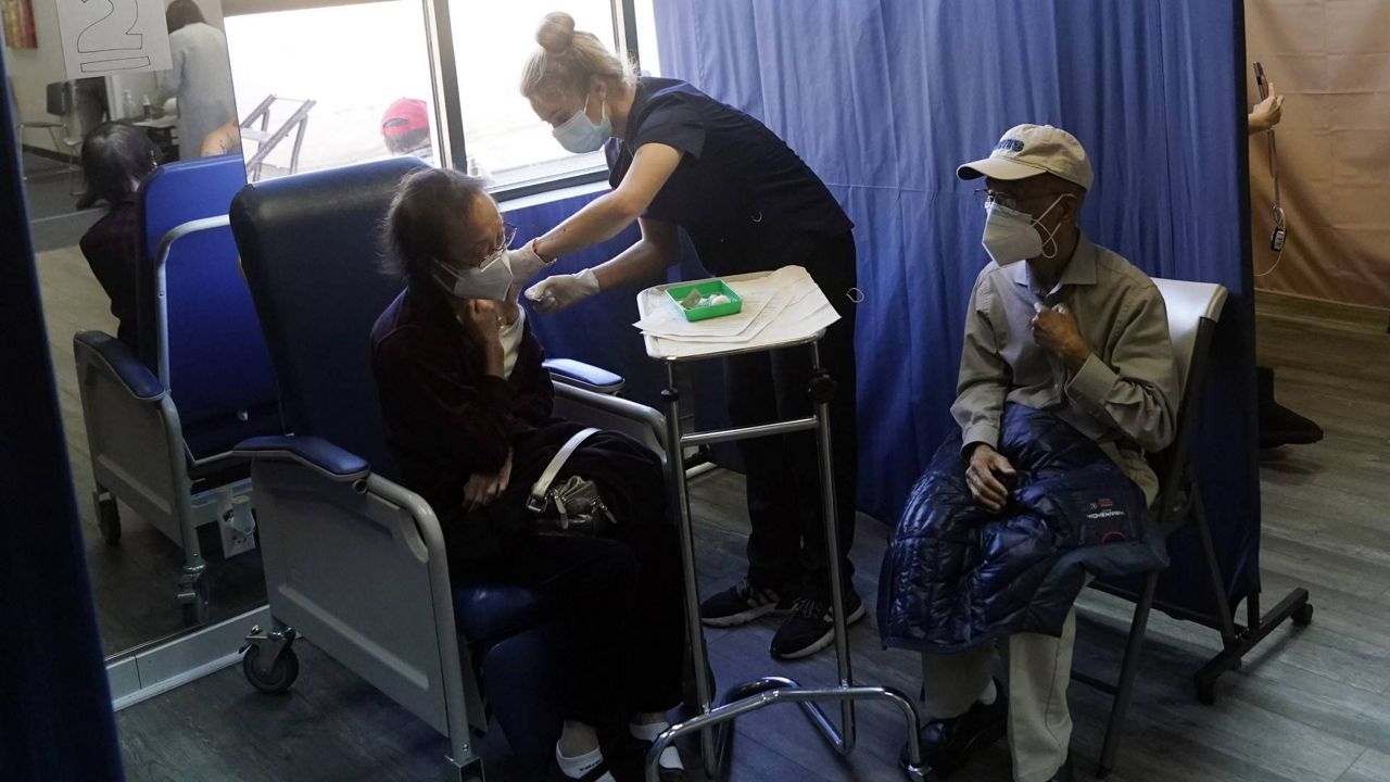 Patients receive a dose of Pfizer's COVID-19 vaccine at Families Together of Orange County Community Health Center, Feb. 26, 2021, in Tustin, Calif. (AP Photo/Marcio Jose Sanchez)