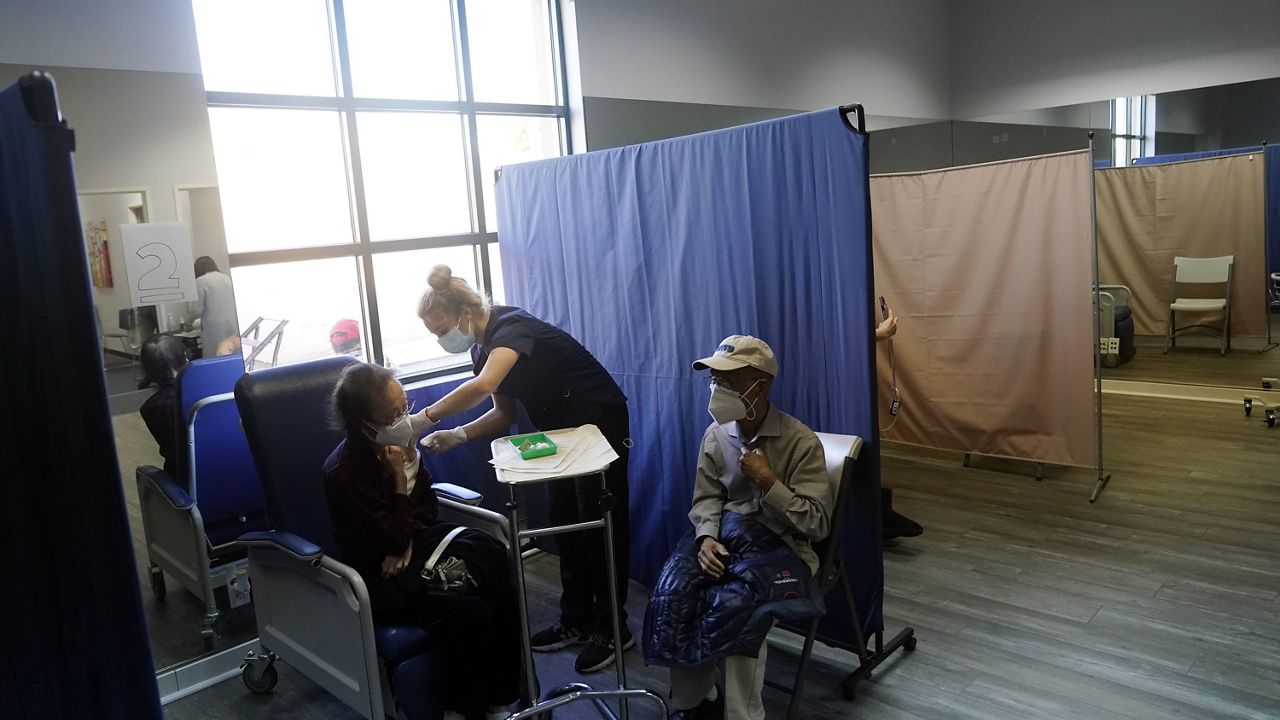 Patients receive a dose of Pfizer's COVID-19 vaccine at Families Together of Orange County Community Health Center, Friday, Feb. 26, 2021, in Tustin, Calif. (AP Photo/Marcio Jose Sanchez)