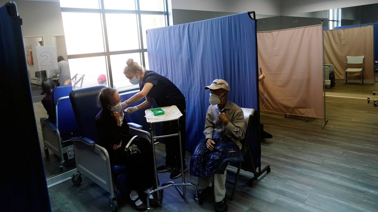 Patients receive a dose of Pfizer's COVID-19 vaccine at Families Together of Orange County Community Health Center, Feb. 26, 2021, in Tustin, Calif. (AP Photo/Marcio Jose Sanchez)