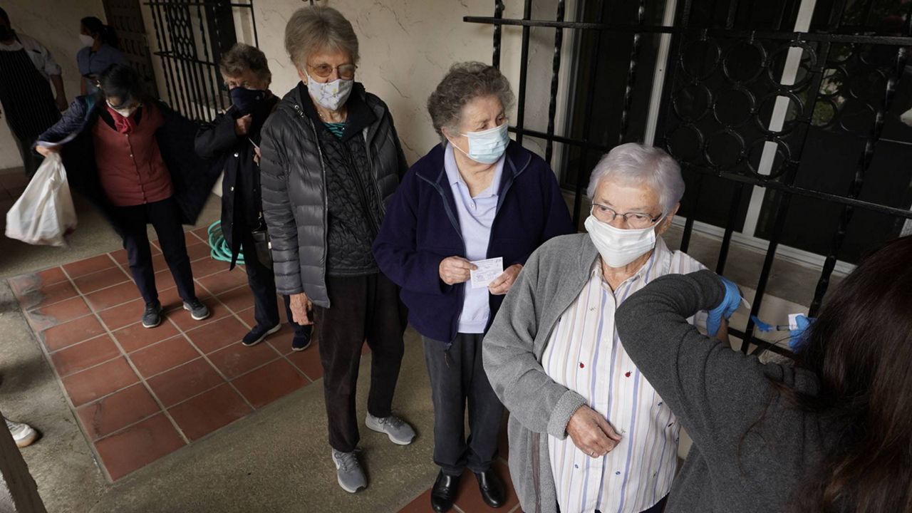 Registered nurse Liliana Ocampo, right, administers a Moderna COVID-19 vaccine to retired nuns at The Sisters of St. Joseph of Carondelet independent living center in L.A., Wednesday, March 3, 2021. (AP Photo/Damian Dovarganes)