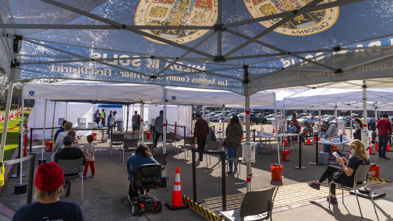 People wait under tents for their turn to be vaccinated at the St. John's Well Child and Family Center just-opened COVID-19 vaccination site at the East Los Angeles Civic Center, March 4, 2021. (AP/Damian Dovarganes)