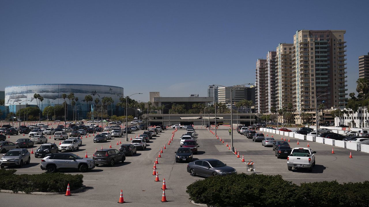 Motorists line up at a COVID-19 vaccination site in Long Beach, Calif., Friday, March 5, 2021. More than 27 million Americans fully vaccinated against the coronavirus will have to keep waiting for guidance from U.S. health officials for what they should and shouldn't do. The Biden administration said Friday it's focused on getting the guidance right and accommodating emerging science. (AP Photo/Jae C. Hong)