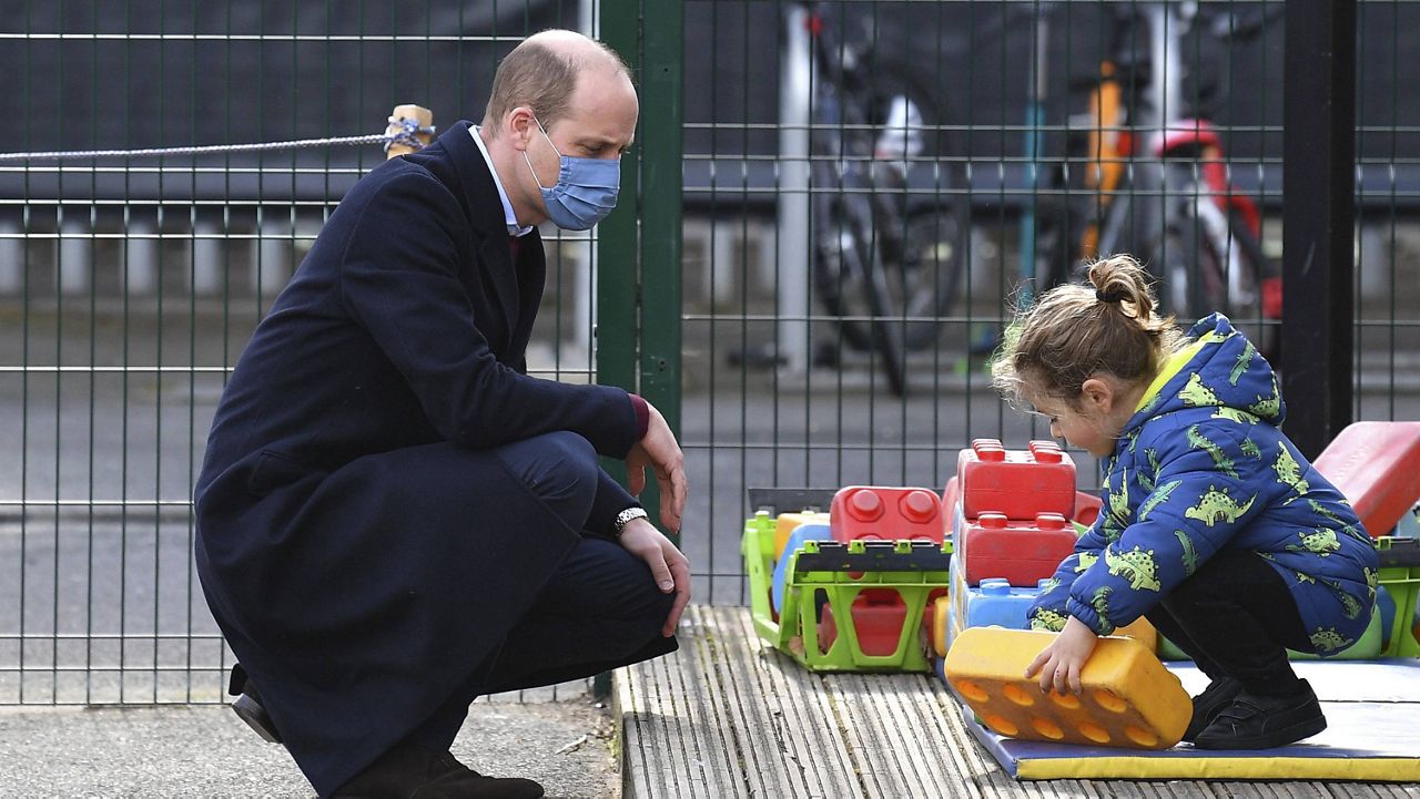 Britain's Prince William watches a child in the playground during a visit with Kate, Duchess of Cambridge, to school in east London on Thursday. (Justin Tallis/Pool via AP)