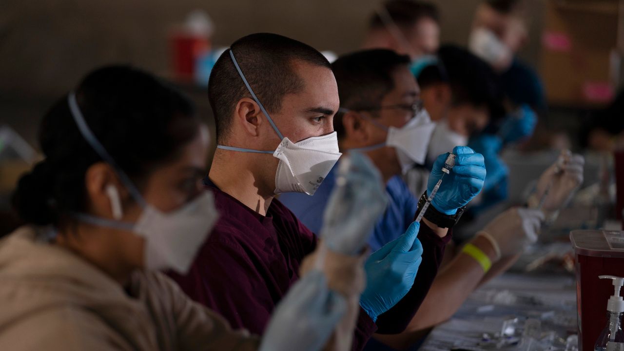Members of the National Guard fill syringes with Pfizer's COVID-19 vaccine at a vaccination site in Long Beach, Calif., Friday, March 5, 2021. AP21070671149916.jpg  (AP Photo/Jae C. Hong)