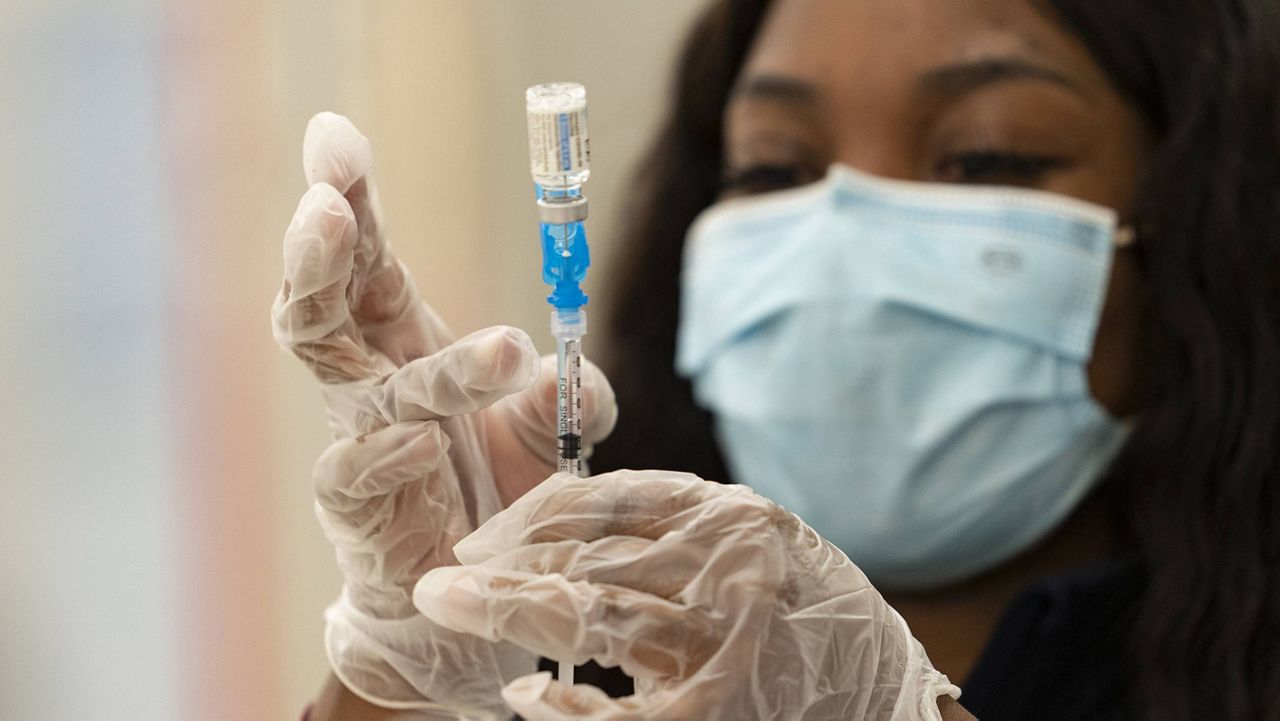 In this Thursday, March 11, 2021, file photo, a health worker loads syringes with the vaccine on the first day of the Johnson & Johnson vaccine being made available to residents at the Baldwin Hills Crenshaw Plaza in Los Angeles. (AP Photo/Damian Dovarganes, File)