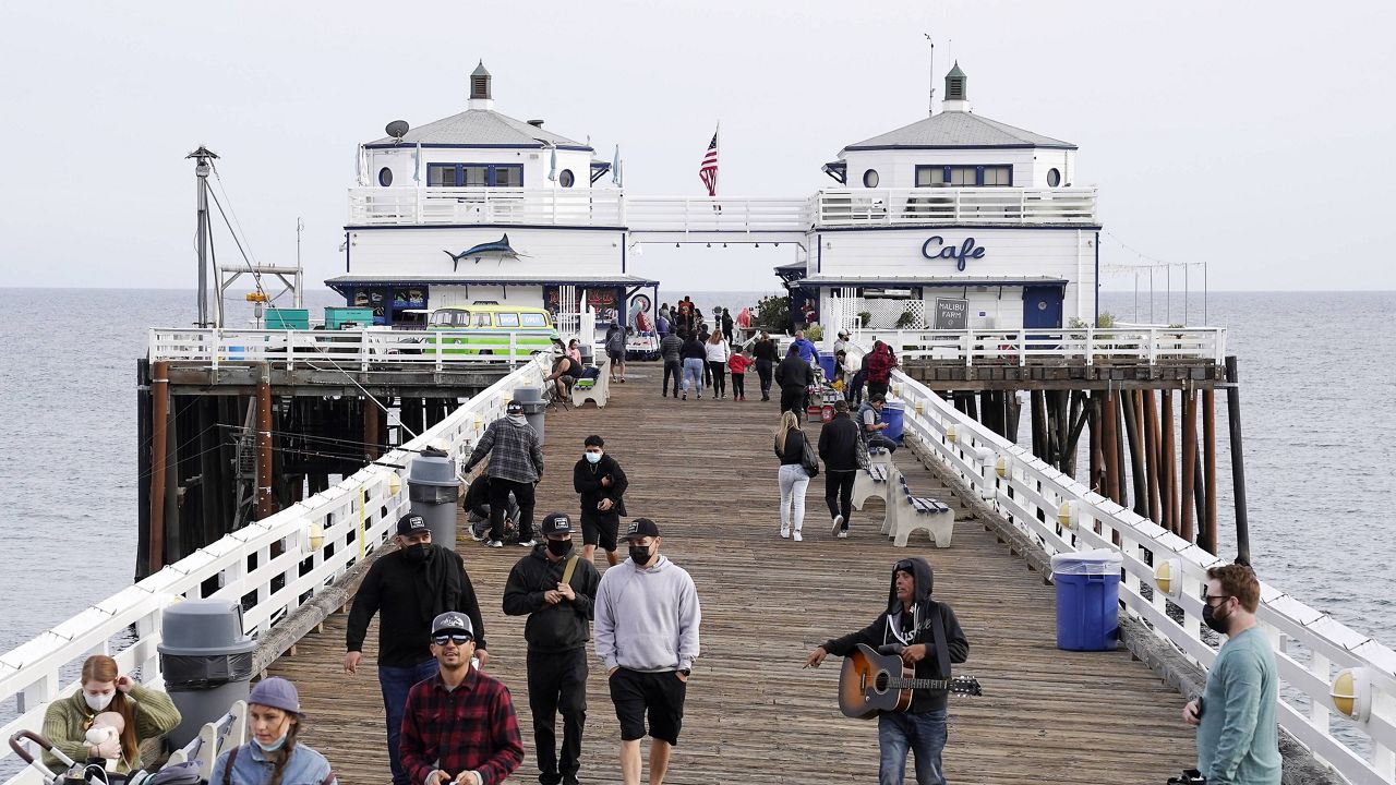 People walk on the Malibu Pier Sunday, March 14, 2021, in the Malibu section of Los Angeles. (AP Photo/Mark J. Terrill)