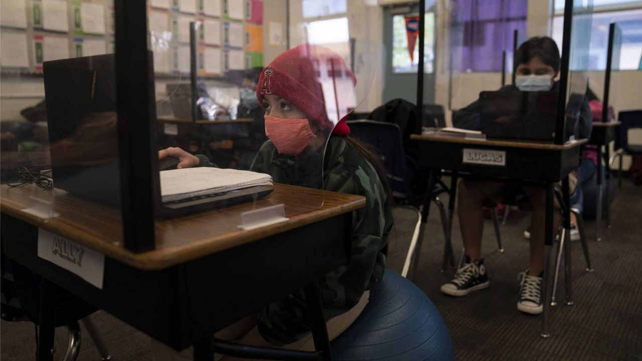 Fifth grader Ally Cortez works on her computer at West Orange Elementary School in Orange, Calif., Thursday, March 18, 2021. (AP Photo/Jae C. Hong)