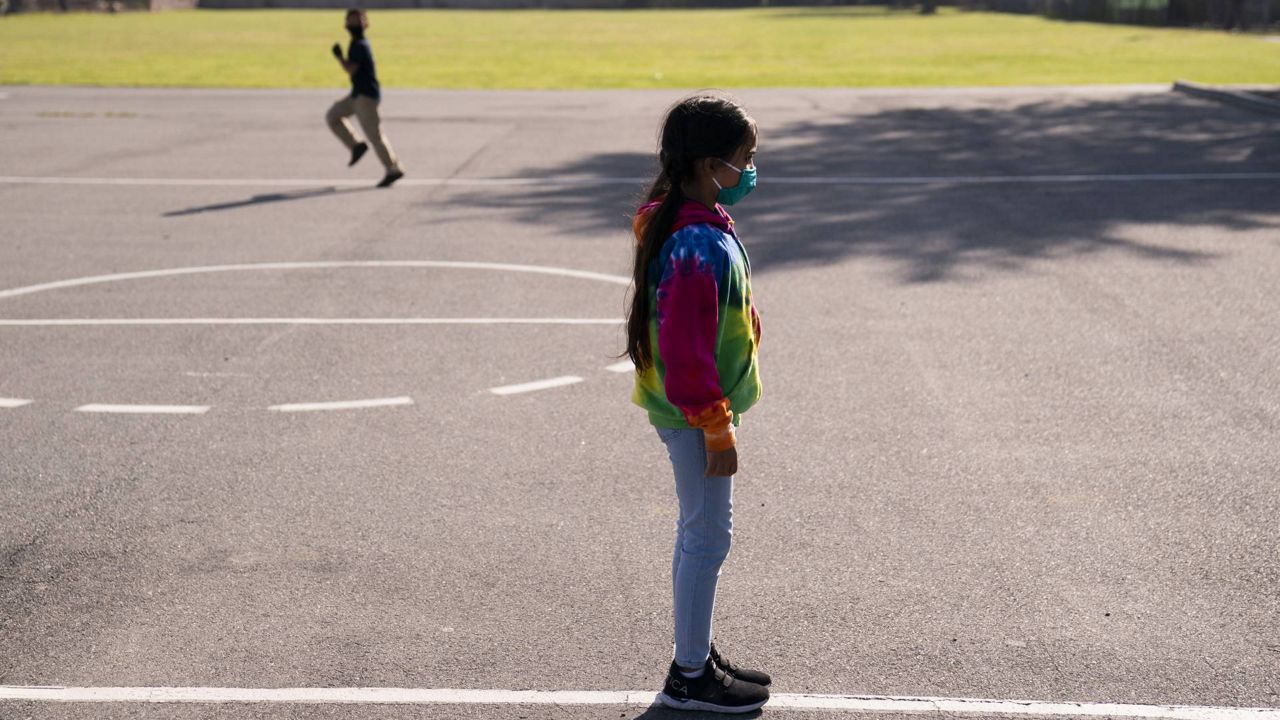 Angelique Larranga, 8, waits for her turn to play in a playground at West Orange Elementary School in Orange, Calif., Thursday, March 18, 2021. (AP Photo/Jae C. Hong)