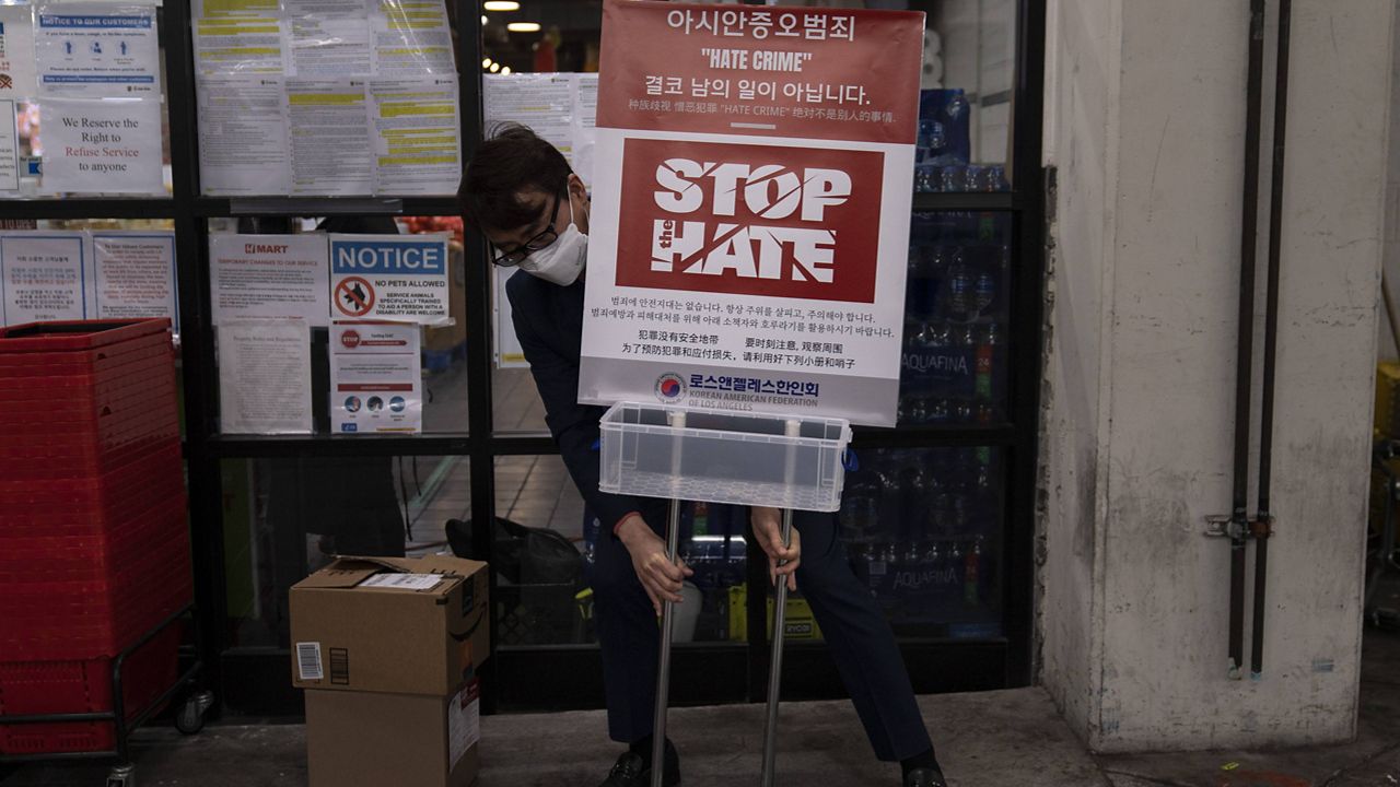 Peter Chang from the Korean American Federation of Los Angeles places a poster to bring awareness to anti-Asian hate crimes Tuesday, March 23, 2021, in the Koreatown neighborhood of Los Angeles. (AP Photo/Jae C. Hong)