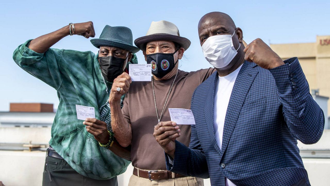 Arsenio Hall, Danny Trejo, and Magic Johnson pose for a photo after they all got COVID-19 vaccine shots at USC as a part of a vaccination awareness event, Wednesday, March 24, 2021. (Gina Ferazzi/Los Angeles Times via AP, Pool)