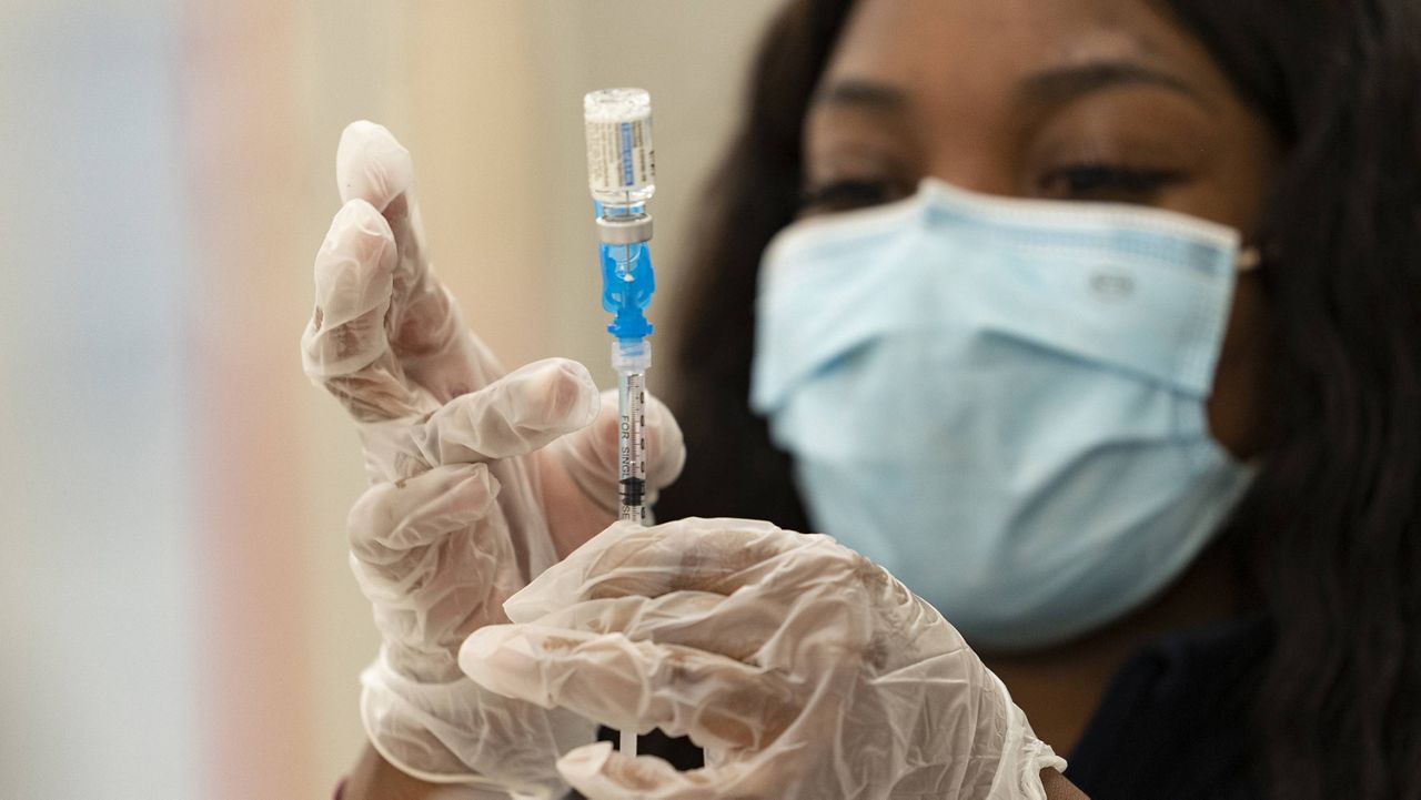 In this March 11, 2021, file photo, a health worker loads syringes with the vaccine on the first day of the Johnson & Johnson vaccine being made available to residents at the Baldwin Hills Crenshaw Plaza in Los Angeles. (AP Photo/Damian Dovarganes, File)