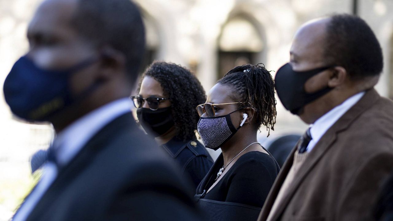 Georgia State Rep. Park Cannon (center) walks beside Martin Luther King III as she returns to the state Capitol in Atlanta on Monday after being arrested last week for knocking on the governor's office door as he signed voting legislation. (AP Photo/Ben Gray)