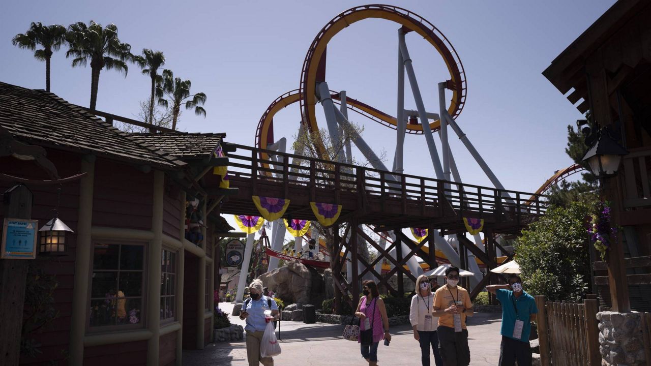 Visitors with face masks attend the Knott's Taste of Boysenberry Festival at Knott's Berry Farm in Buena Park, Calif., March 30, 2021. (AP Photo/Jae C. Hong)