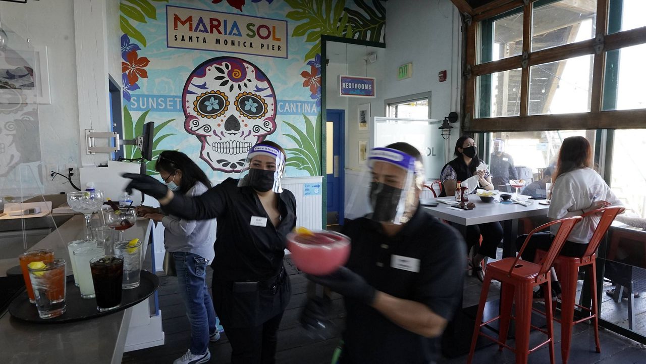 People have drinks indoors at Maria Sol on the Santa Monica Pier as they open for indoors service in Santa Monica, Calif., Wednesday, March 31, 2021. (AP Photo/Damian Dovarganes)