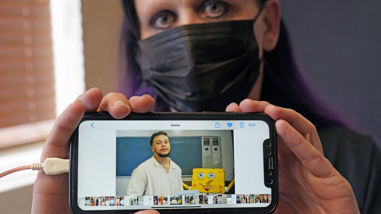 Carrie Shipp shows a photo of her incarcerated 21-year-old son, Matthew Shipp, that she keep on her cellphone. (AP Photo/LM Otero)