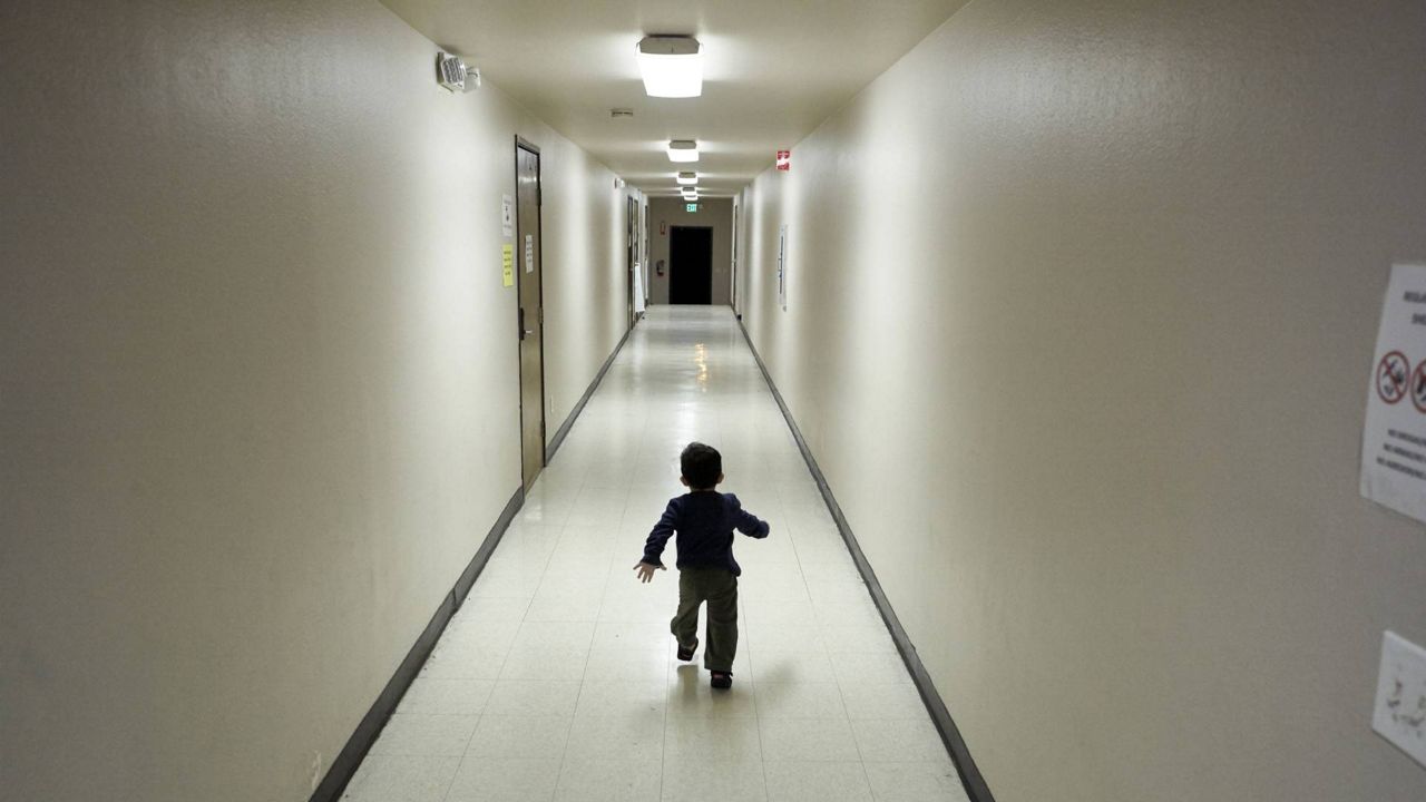 In this Dec. 11, 2018 file photo, an asylum-seeking boy from Central America runs down a hallway after arriving from an immigration detention center to a shelter in San Diego. (AP Photo/Gregory Bull)