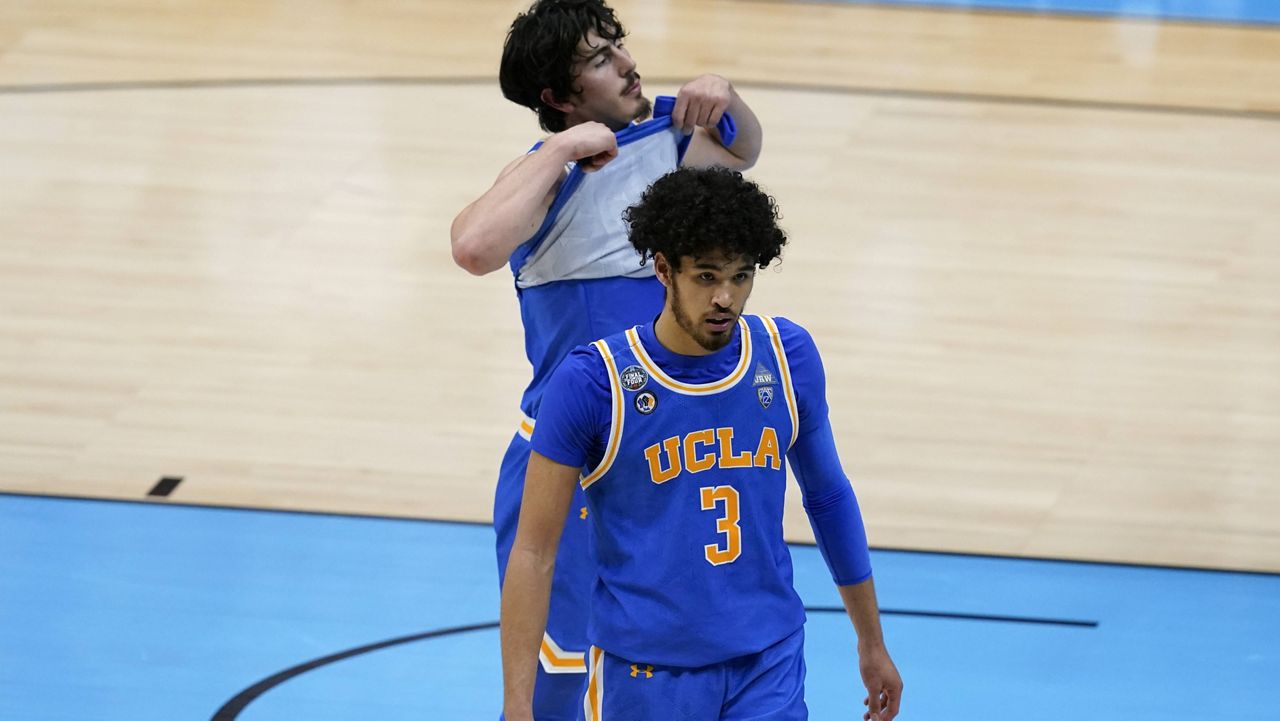 UCLA guard Johnny Juzang (3) and guard Jaime Jaquez Jr., rear, walk off the court after a men's Final Four NCAA college basketball tournament semifinal game against Gonzaga , Saturday, April 3, 2021, at Lucas Oil Stadium in Indianapolis. Gonzaga won 93-90 in overtime. (AP Photo/Darron Cummings)