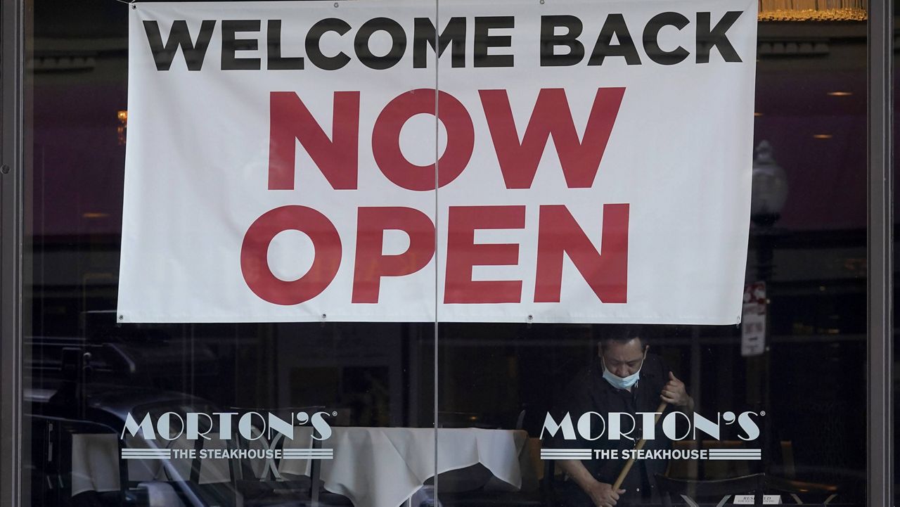 In this March 4 file photo, a sign reading "Welcome Back Now Open" is posted on the window of a Morton's Steakhouse restaurant in San Francisco. 