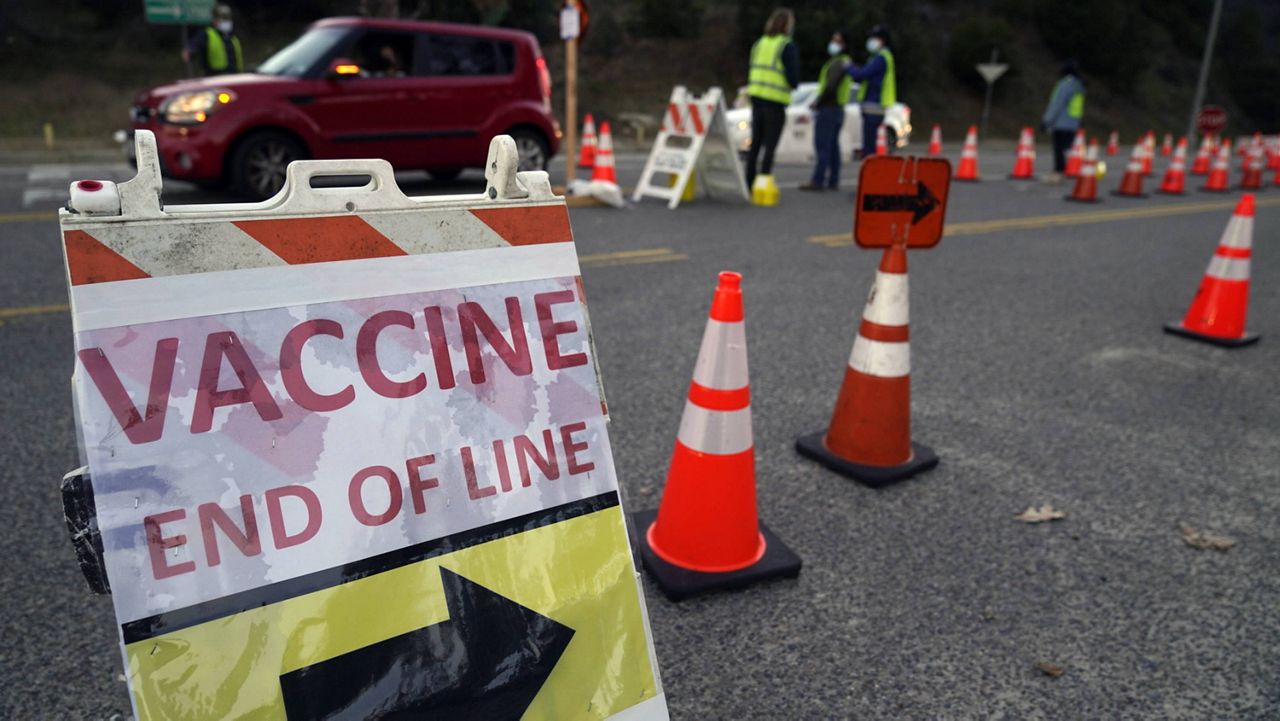 In this Jan. 30, 2021, file photo, drivers with a vaccine appointment enter a mega COVID-19 vaccination site set up in the parking lot of Dodger Stadium in Los Angeles, a day after it was temporarily shut down while protesters blocked the entrance. (AP Photo/Damian Dovarganes, File)