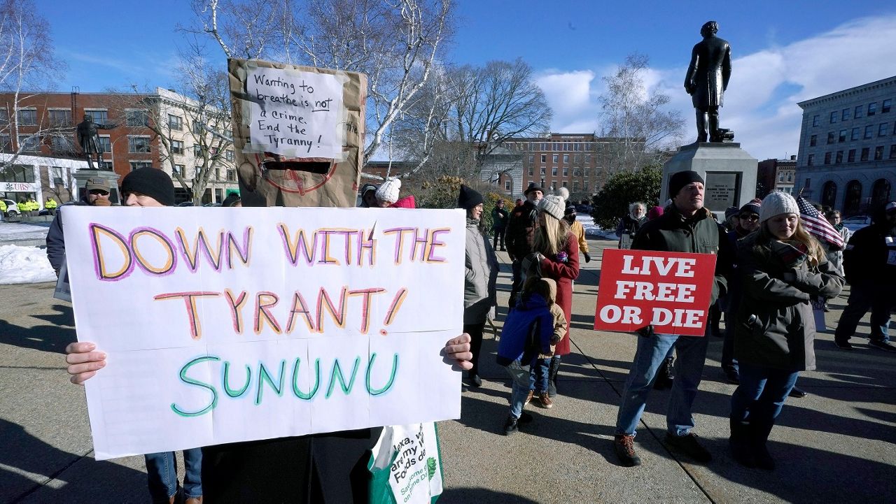 FILE - In this Thursday, Jan. 7, 2021 file photo, people protest outside the Statehouse in Concord, N.H., as Gov. Chris Sununu is inaugurated at noon for his third term as governor. A measure that recently passed New Hampshire's Republican-led House would prohibit governors from indefinitely renewing emergency declarations, as Sununu has done every 21 days for the past year. It would halt emergency orders after 30 days unless renewed by lawmakers. (AP Photo/Charles Krupa)