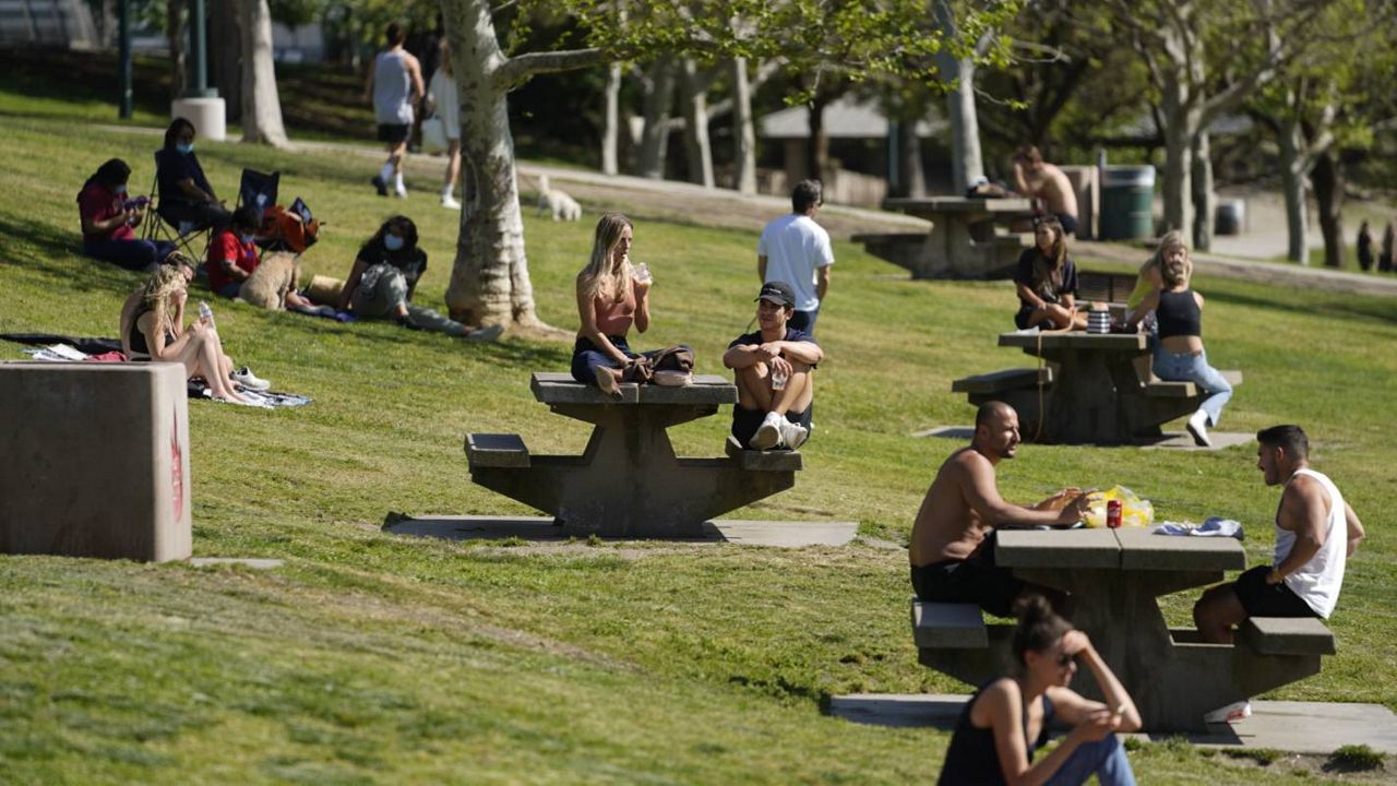 People enjoy the sunny weather at Pan Pacific Park in the Fairfax District of Los Angeles, Thursday, April 8, 2021. (AP Photo/Damian Dovarganes)