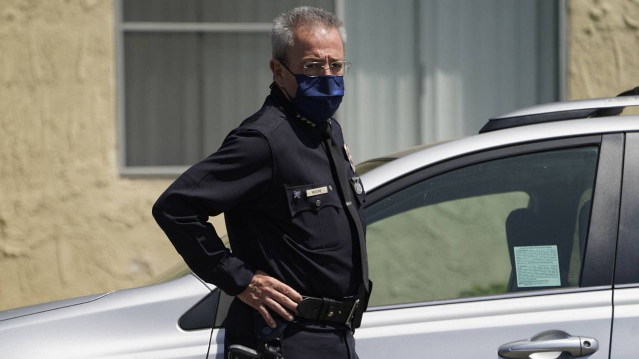 Los Angeles Police Chief Michel Moore stands at the scene as authorities investigate a crime at an apartment complex in Reseda, Calif., April 10, 2021. (AP Photo/Damian Dovarganes)