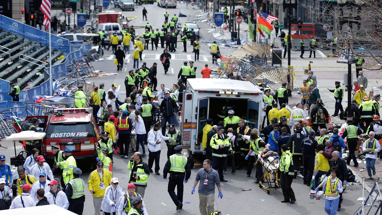 FILE: In this Monday April 15, 2013 file photograph, emergency workers aid injured people at the finish line of the 2013 Boston Marathon following two explosions in Boston. (AP Photo/Charles Krupa, File)