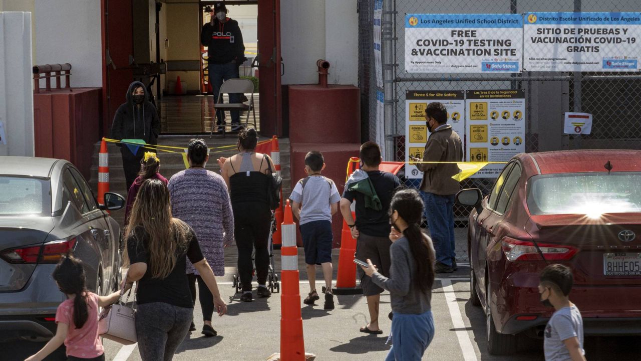 Parents and students arrive at a COVID-19 testing and vaccination site run by the Los Angeles Unified School District in East Los Angeles Thursday, April 15, 2021. (AP Photo/Damian Dovarganes)