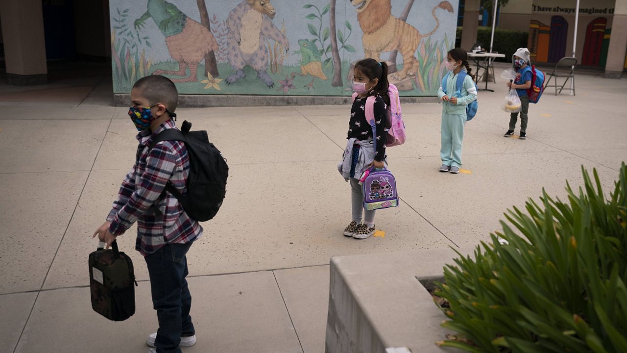 Socially distanced kindergarten students wait for their parents to pick them up on the first day of in-person learning at Maurice Sendak Elementary School in Los Angeles, Tuesday, April 13, 2021. (AP Photo/Jae C. Hong)