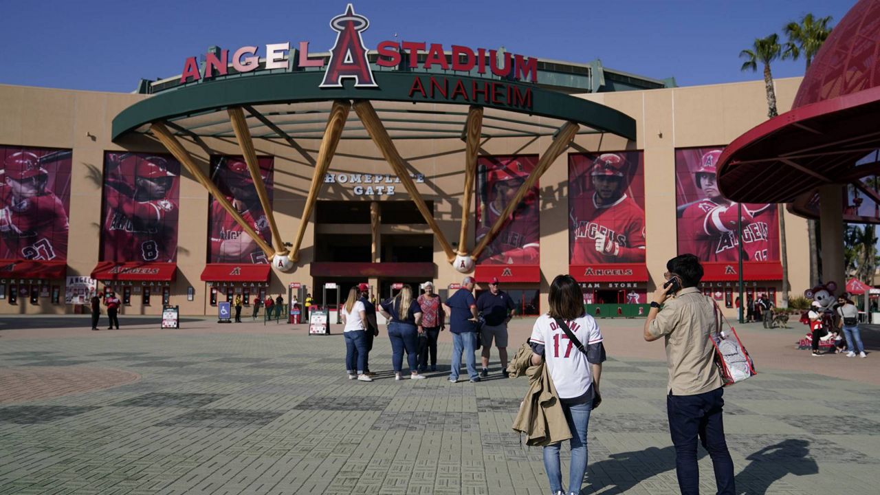 Fans stand outside Angel Stadium when a baseball game between the Minnesota Twins and the Los Angeles Angels was postponed April 17, 2021, in Anaheim, Calif. (AP Photo/Ashley Landis)