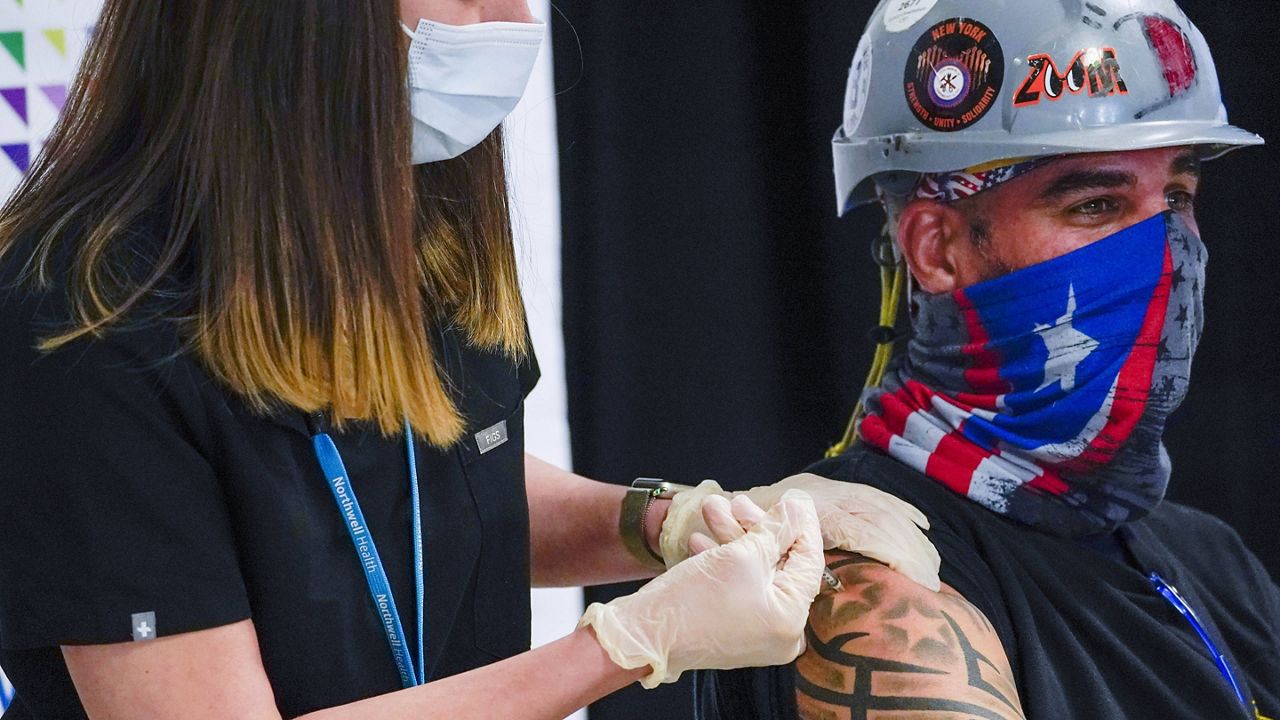 A nurse injects Demetrius Buttelman, a sheet metal worker, with the Pfizer vaccine in Elmont, N.Y. (AP Photo/Mary Altaffer, Pool, File)