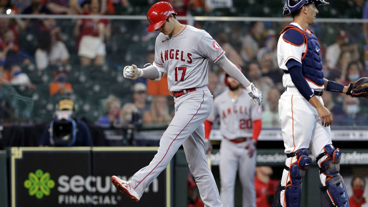 LA Angels designated hitter Shohei Ohtani crosses the plate on his home run next to Houston Astros catcher Jason Castro, right, during a baseball game Saturday, April 24, 2021, in Houston. (AP Photo/Michael Wyke)