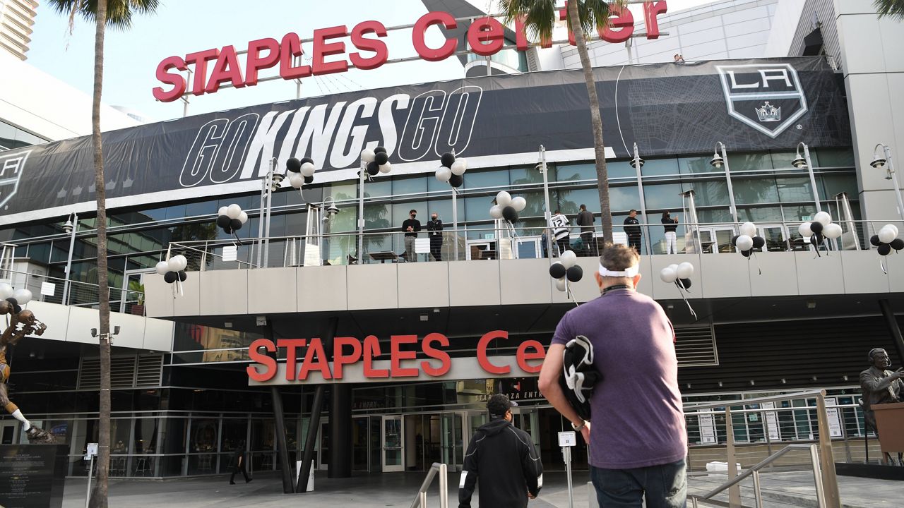 Hockey fans enter Staples Center before an NHL hockey game between the Los Angeles Kings and Arizona Coyotes, Saturday, April 24, 2021, in Los Angeles. (AP Photo/Michael Owen Baker)