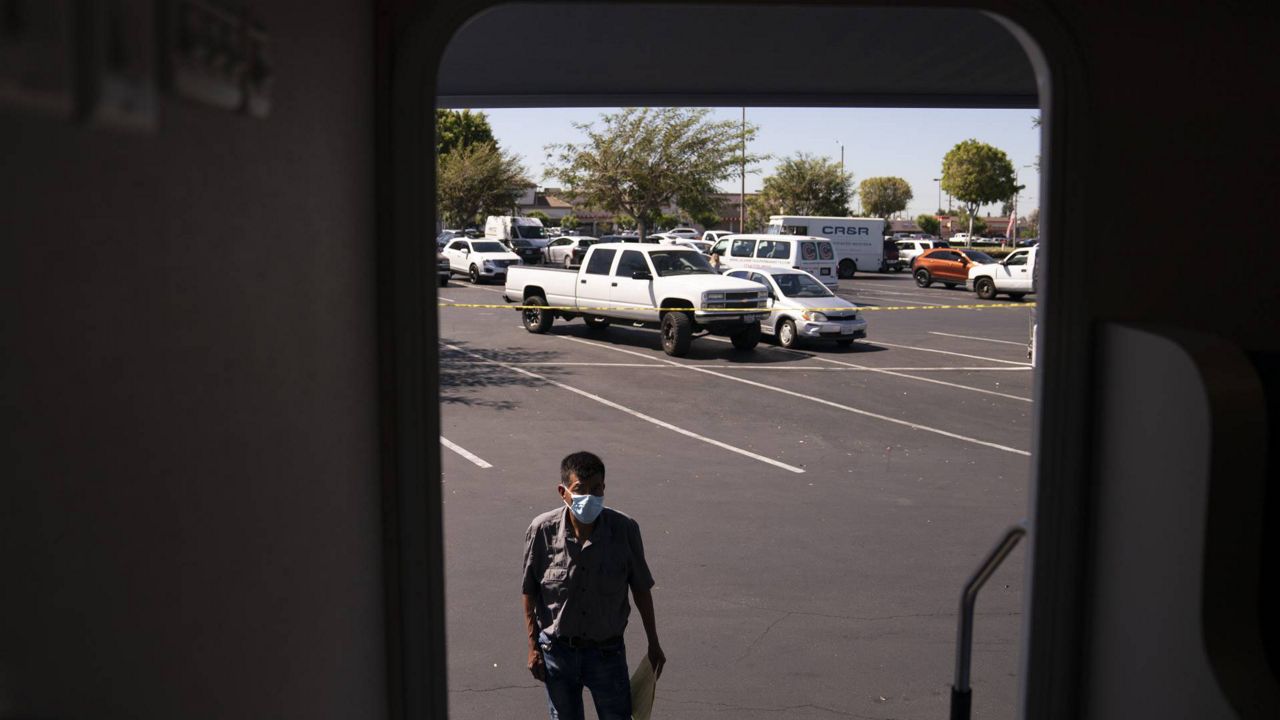Hugo Rodriguez waits to receive the Moderna COVID-19 vaccine at a mobile clinic set up in the parking lot of a shopping center in Orange, Calif., April 29, 2021. (AP Photo/Jae C. Hong)