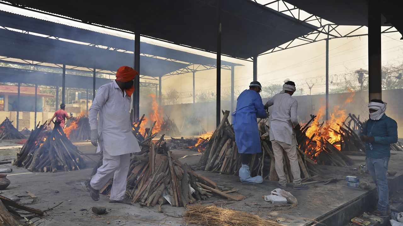 Multiple funeral pyres of COVID-19 victims burn as relatives perform last rites at a crematorium in New Delhi, India, Friday, April 30, 2021. (AP Photo)