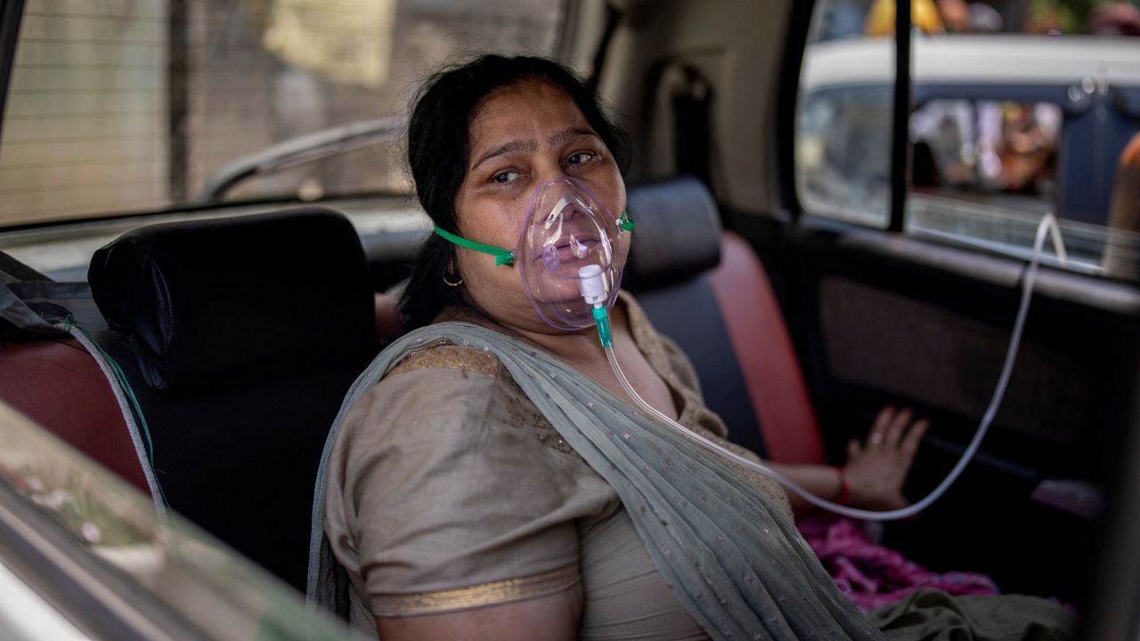 A COVID-19 patient sits in a car and breathes with the help of oxygen provided by a Gurdwara, a Sikh house of worship, in New Delhi, India.