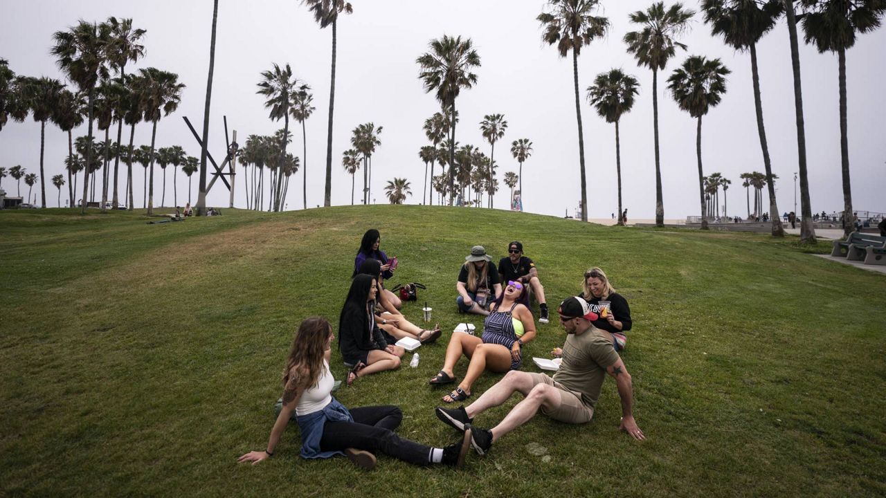 A group of friends, who said they are fully vaccinated for COVID-19, mingle on the beach in the Venice section of Los Angeles, Wednesday, May 5, 2021. (AP Photo/Jae C. Hong)